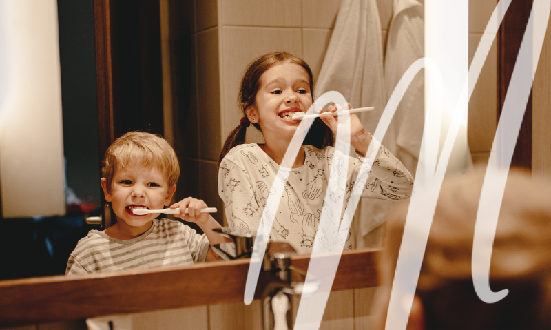 little brother and big sister brushing their teeth