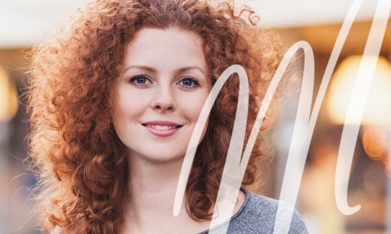 woman with lots of curly hair smiling