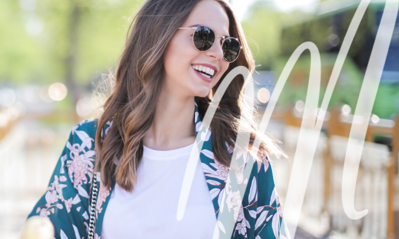 woman in sunglasses and flowered top smiling